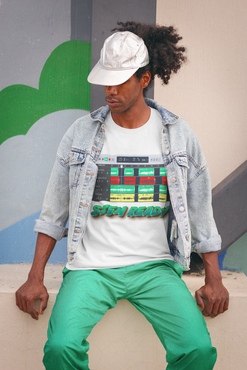 Person wearing a denim jacket, white STEM READY t-shirt with colorful text, and green pants sitting on a ledge.
